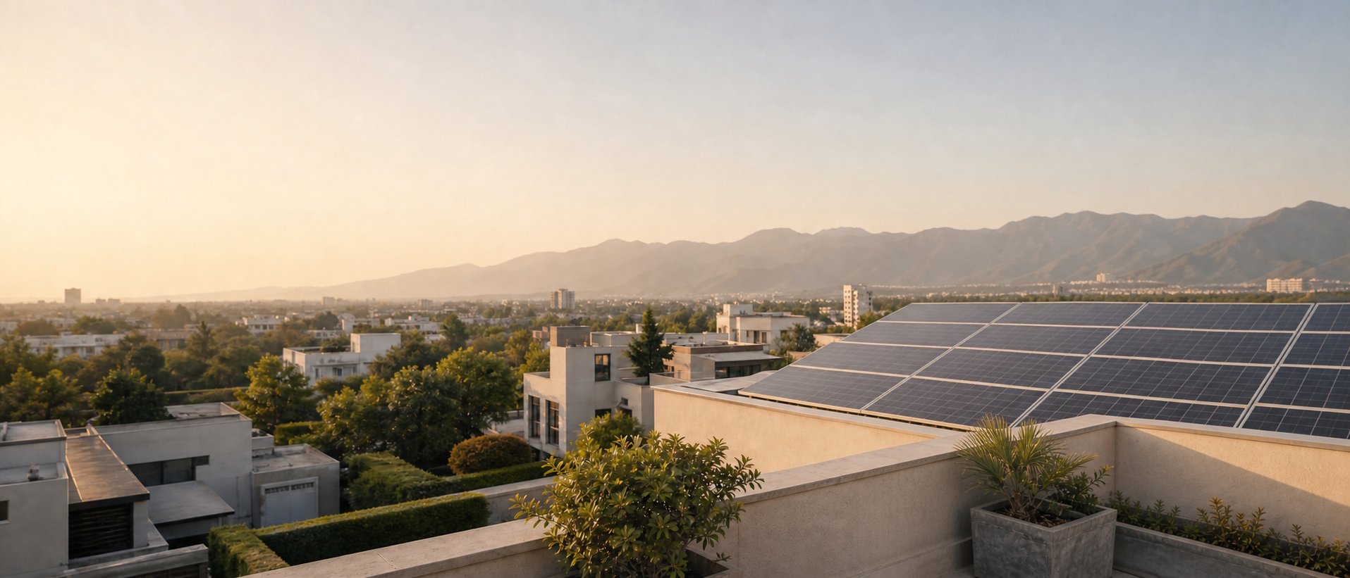 Solar panels on a rooftop overlooking a Pakistani neighbourhood at sunset